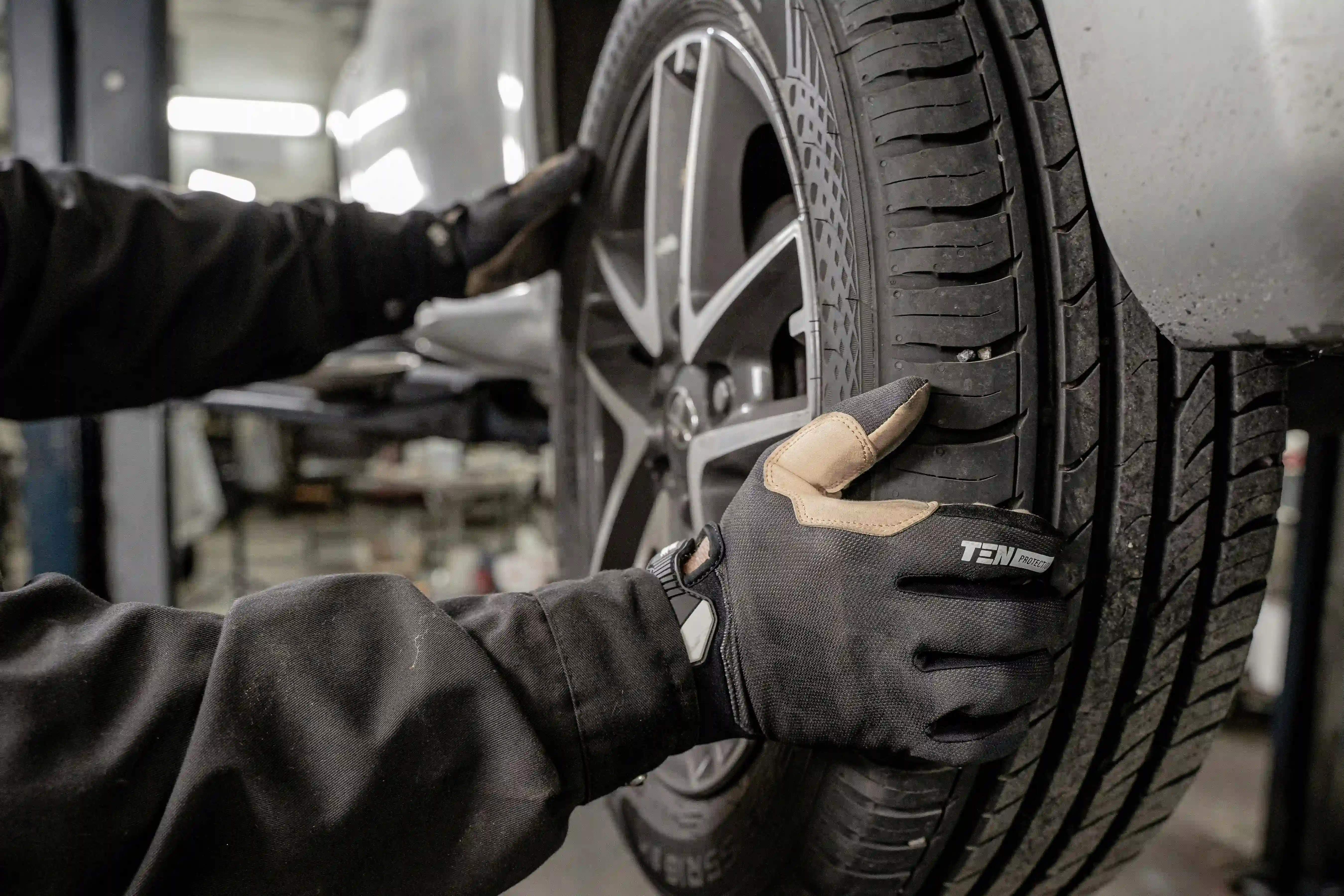 Mechaniker setzt in der Werkstatt ein Rad an die Nabe